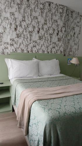 a bedroom with a bed with a floral wallpaper at comfort hotel 413 anfitriã in Taguatinga