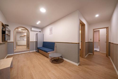 a living room with a blue couch and a table at Geoje Hound Hotel & Spa in Geoje 