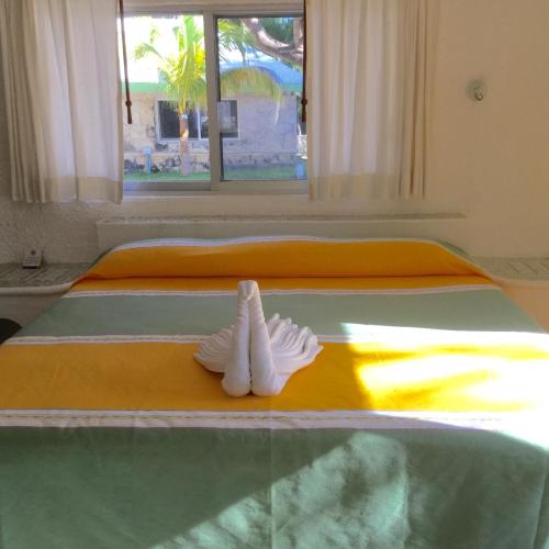 a bed with a pair of mitts sitting on it at Hotel Club Akumal Caribe in Akumal
