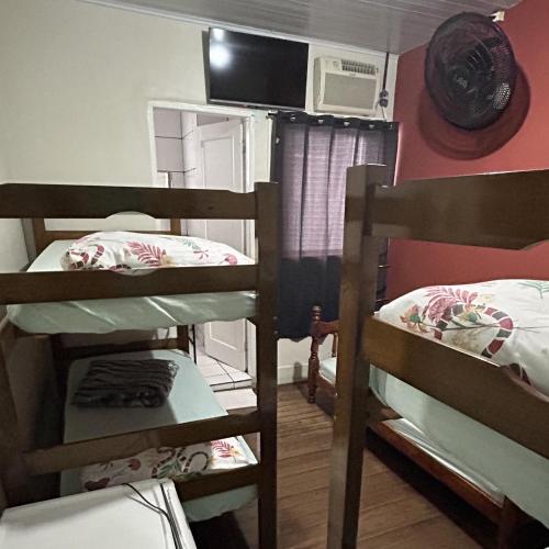 a room with two bunk beds and a microwave at Pousada Orquidário in Santos
