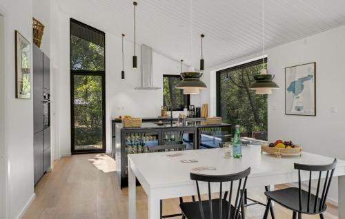 a kitchen and dining room with a white table and chairs at Cozy Home In Læsø With Kitchen in Læsø