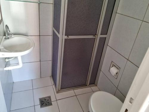 Un baño con ducha, inodoro y lavabo. en Apartamento Centro Guarapari- ES, en Guarapari