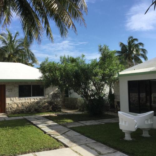 a house with a white bench in the yard at Hotel Club Akumal Caribe in Akumal