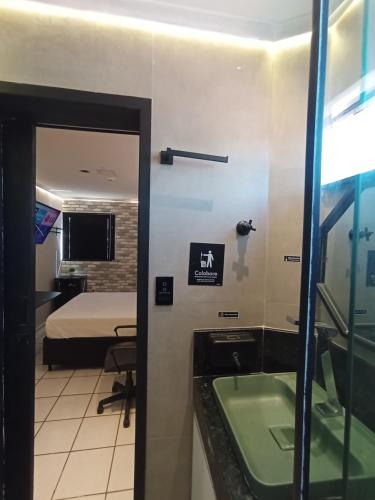 a room with a bed and a bathroom with a mirror at Praia do Bessa, Caribessa - Quarto Privativo - Conforto, Paz e Sossego, excelente para descansar, trabalhar ou estudar in João Pessoa