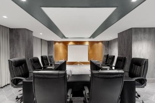 a conference room with a table and chairs and a whiteboard at Summit Galleria Cebu in Cebu City