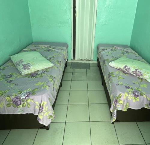 two beds sitting next to each other in a room at Pousada Orquidário in Santos