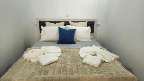 a bed with white sheets and blue pillows at Studio Chic, Rezerva acum! Central, cafea, ceai, apa, parcare publica gratuita, baie cu cabina si cada in Craiova