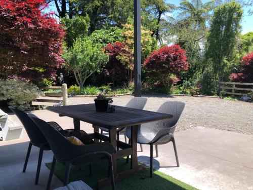 a black table and chairs on a patio at Luxury Farm Escape Tiny Home New Plymouth-Egmont Village in Egmont Village