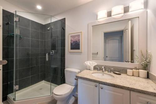 a bathroom with a shower and a toilet and a sink at Location with Views - 2BDR Penthouse Whistler Village in Whistler