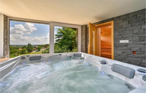 a hot tub in a room with a large window at 3 Bedroom Pet Friendly Home In Ludbreg in Ludbreg