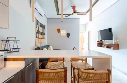 a kitchen with a counter with chairs and a table at Apartment with Private Jacuzzi, Rooftop Pools & Free beach club in Tulum