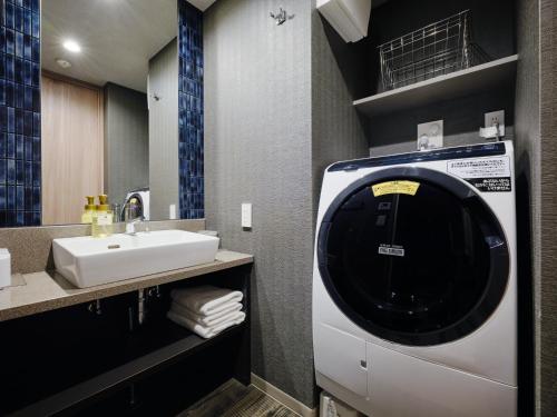 a bathroom with a washing machine and a sink at MONday Apart Ueno Shinokachimachi in Tokyo