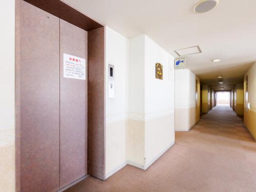 a hallway in an office building with a long corridor at Tabist ASAHIKAWA STATION HOTEL in Asahikawa
