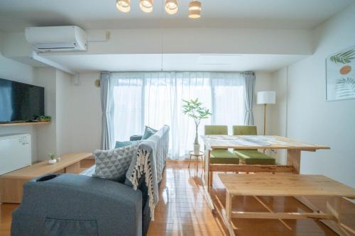 a living room with a table and a dining room at Sapporo irios cozy inn in Sapporo