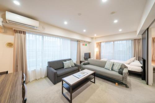a living room with a couch and a chair at Pangoo Shinagawa in Tokyo