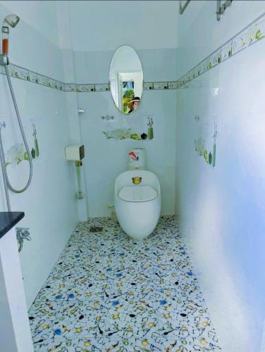 a bathroom with a toilet and a mirror at Hoàng Nga 2 Homestay in Phan Thiet