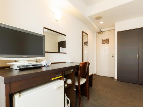 a room with a desk with a television on it at Tabist ASAHIKAWA STATION HOTEL in Asahikawa
