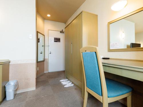 a waiting room with a blue chair in a bathroom at Tabist ASAHIKAWA STATION HOTEL in Asahikawa