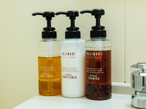 three bottles of liquids sitting on a counter at Tabist ASAHIKAWA STATION HOTEL in Asahikawa