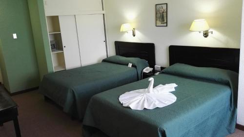 una habitación de hotel con 2 camas con una flor. en Nuevo Maragato Hotel & Hostel en San José