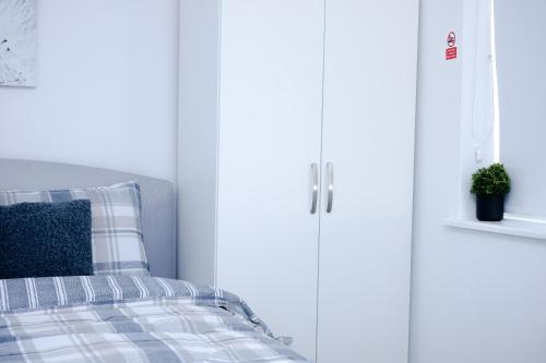 a bed with a blue pillow next to a white door at Hope Deluxe King Bedroom Manchester in Middleton