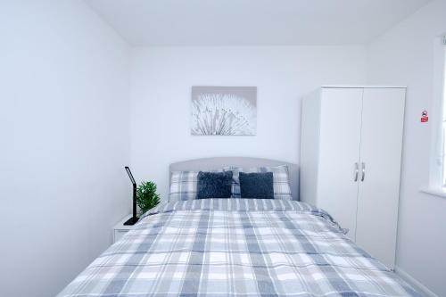 a white bedroom with a bed with blue pillows at Hope Deluxe King Bedroom Manchester in Middleton