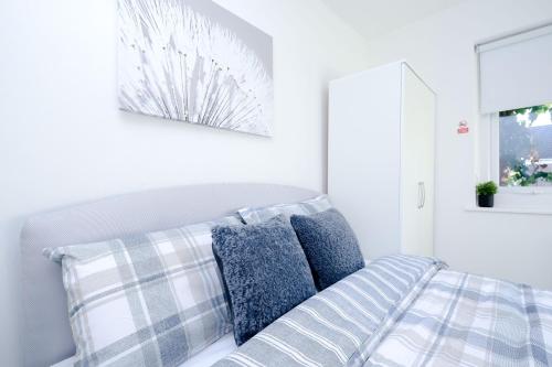 a bedroom with a bed with blue and white pillows at Hope Deluxe King Bedroom Manchester in Middleton