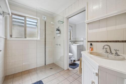 une salle de bain avec un lavabo et des toilettes dans l'établissement Beach Cottage, à Woolgoolga