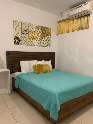 a bedroom with a bed with a blue blanket on it at Los Soles Suite Mall del Sol Guayaquil Airport in Guayaquil