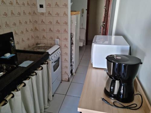 a kitchen with a coffee maker on a counter at Apartamento Centro Guarapari- ES in Guarapari