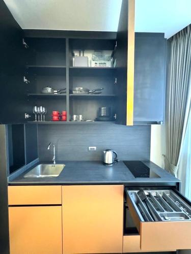 a kitchen with a sink and a stove at Edge Central Pattaya Sea View in Pattaya