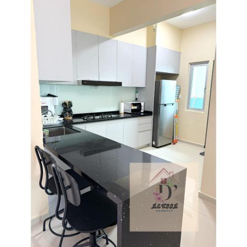a kitchen with white cabinets and a black counter top at D' Alyssa Homestay Perda in Bukit Mertajam