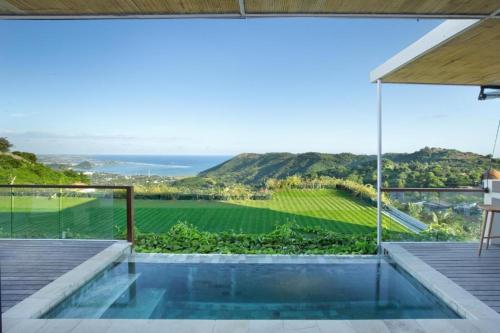 a villa with a pool and a view of a vineyard at Angel's Villa & Resort in Selong