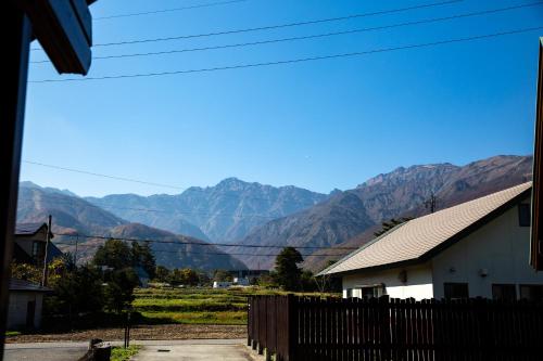 a view of a mountain range from a house at Three Peaks Log スリーピークス ログ in Hakuba