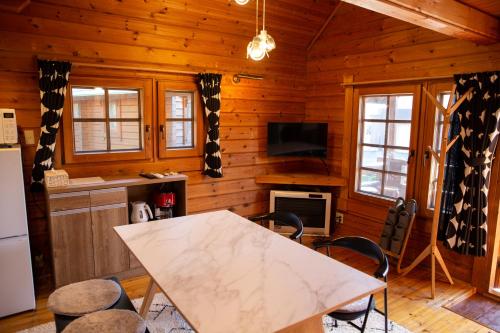 a kitchen with a table and chairs in a cabin at Three Peaks Log スリーピークス ログ in Hakuba