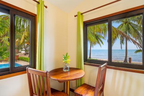 a table and chairs in a room with a view of the ocean at Coconut Row Boutique Hotel in Hopkins