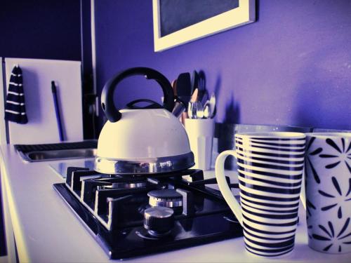 a tea kettle on a stove with plates and a cup at The Daiquiri Shaq in St Helena Bay