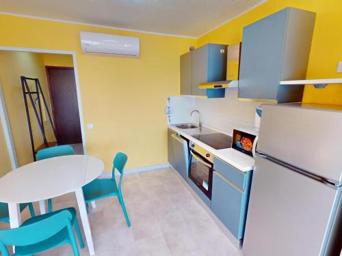 Il comprend une petite cuisine avec une table et un réfrigérateur blanc. dans l'établissement Studio avec terrasse près de la mer, animaux admis - FR-1-196-369, à Menton