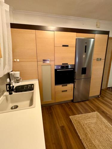 a kitchen with a stainless steel refrigerator and wooden cabinets at LUXE COASTAL RETREAT Apartment in Alexandroupoli