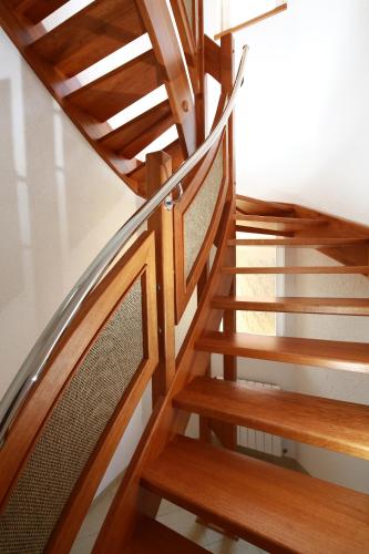 a wooden spiral staircase with a wooden railing at Wellness Penzion Pod Rozhlednou in Kostelec nad Orlicí