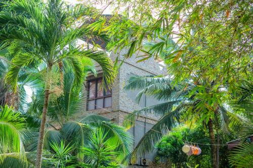 a building with palm trees in front of it at Villa Lanka Relax in Hikkaduwa