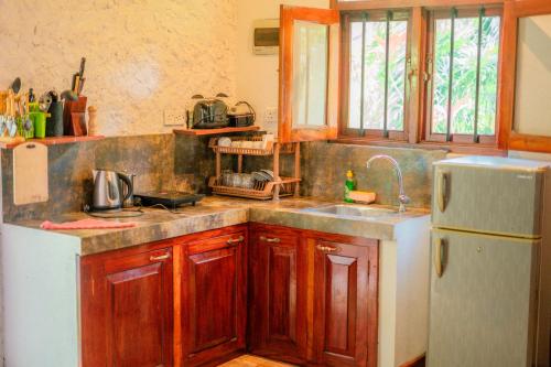 a kitchen with a sink and a refrigerator at Villa Lanka Relax in Hikkaduwa