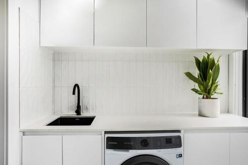 a white kitchen with a sink and a dishwasher at You Yangs Vista in Portarlington