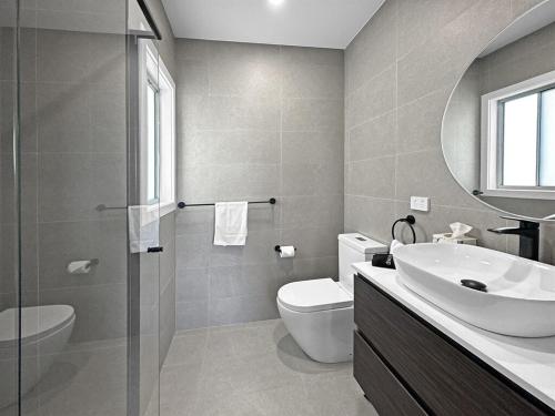 a bathroom with a sink toilet and a mirror at Seaside Village Retreat in Shellharbour