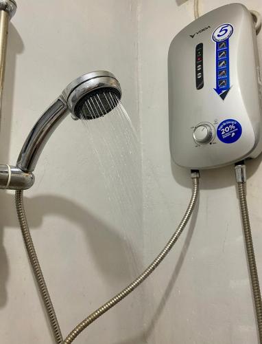 a shower head with water coming out of it at Affordable Staycation Home for 2-3 People! in Dauin