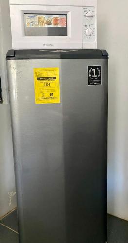 a refrigerator with a microwave on top of it at Affordable Staycation Home for 2-3 People! in Dauin