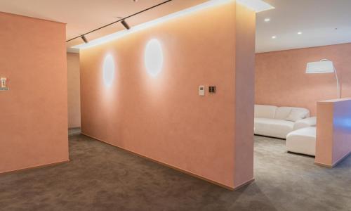 a living room with a white couch and a wall at Jamsil Orosie Tourist Hotel in Seoul