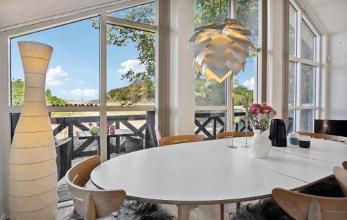 a dining room with a white table and large windows at Cozy Home In Børkop With Wifi in Børkop