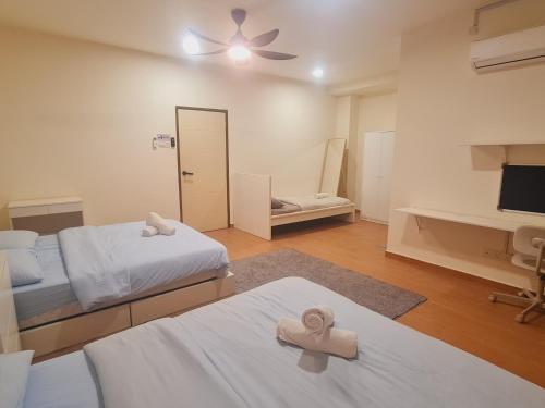 a bedroom with two beds and a desk and a mirror at UniVilla- Ideal Family Home for 18pax in Gelugor