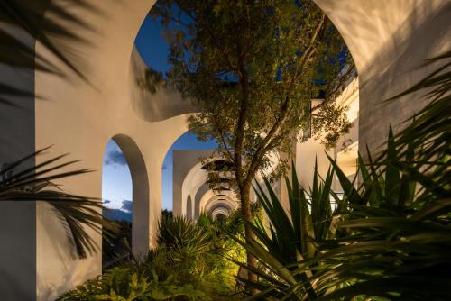 a building with arches and a tree in a courtyard at 大理空岛半山海景民宿 in Dali